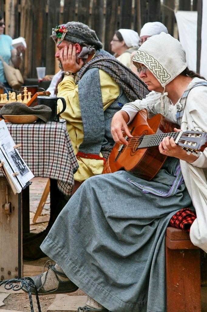 woman playing guitar in old peasants clothes