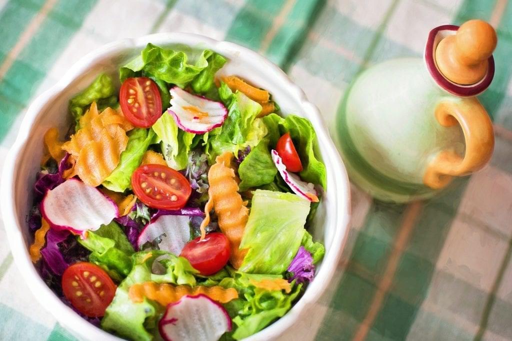 garden salad in bowl with vinegrette cruette