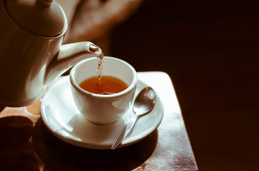 kettle pouring a cup of herbal tea